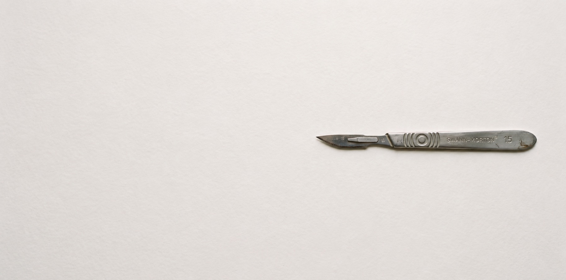 A scalpel resting on blank paper